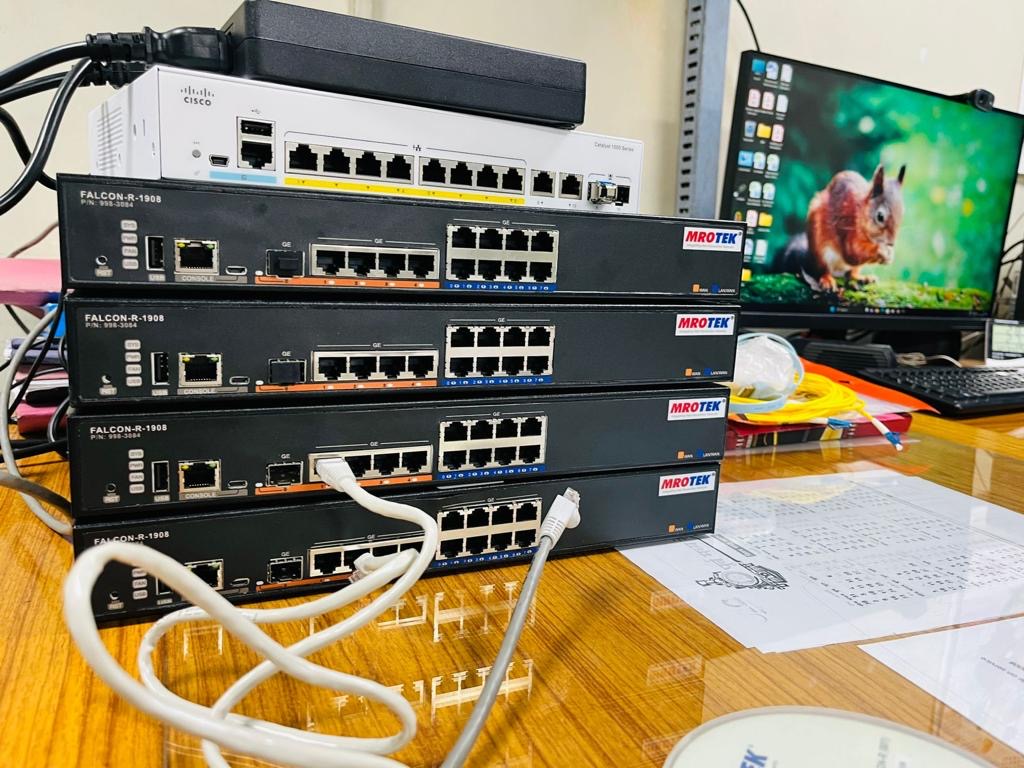 Stack of routers and a Cisco switch being staged