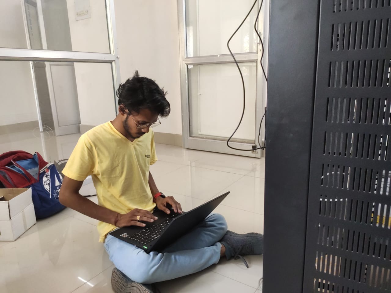 Engineer configuring a network rack from a laptop on site